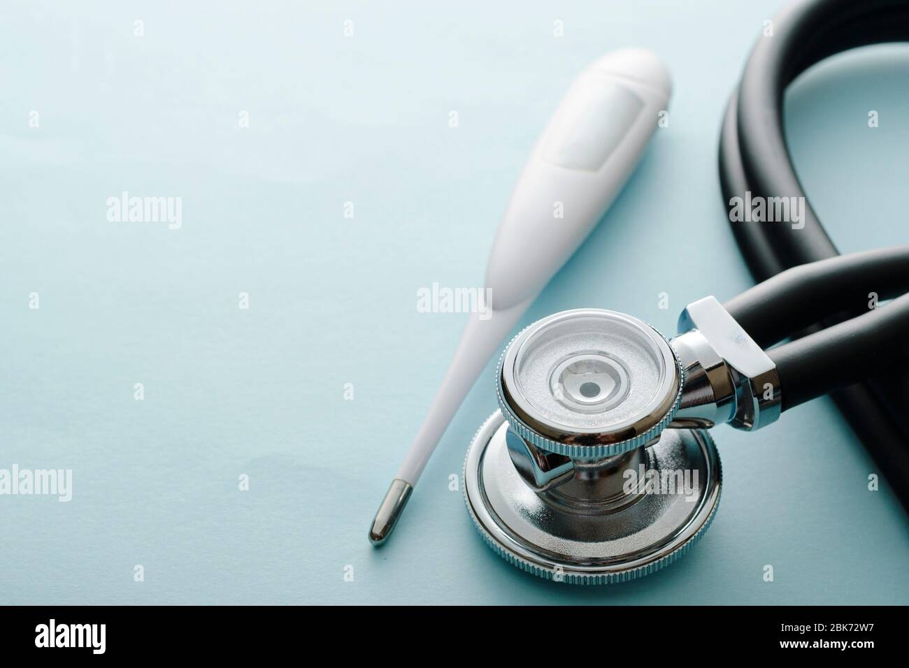 Covid-19 Konzept mit Stethoskop und Thermometer auf weißem Studiohintergrund mit Kopierfläche zur Diagnose oder Überwachung der Atembeschwerden o Stockfoto