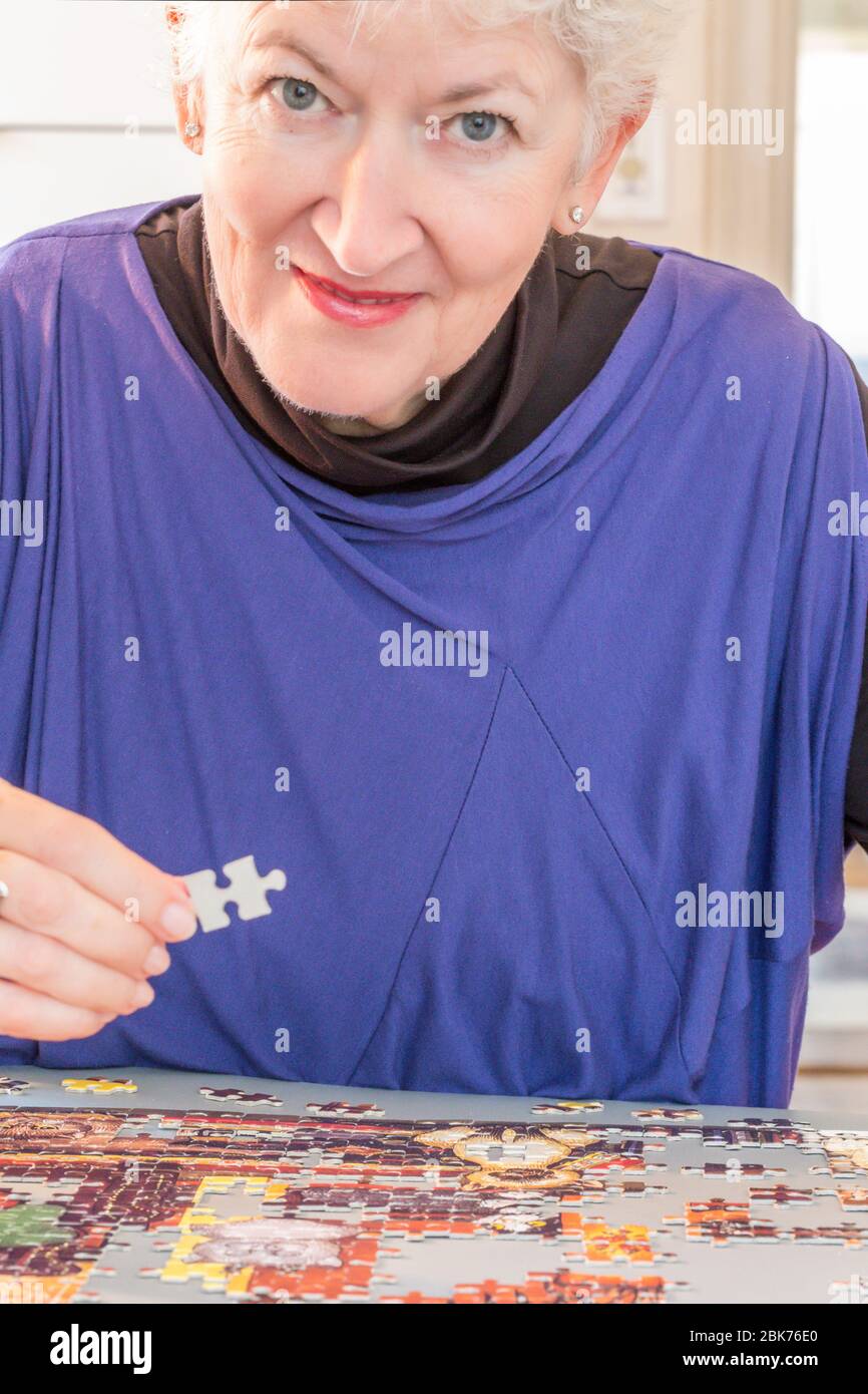 Puzzle wird von einer Rentnerin montiert zeigt ihre Konzentration und akute geistige Schärfe, USA Stockfoto
