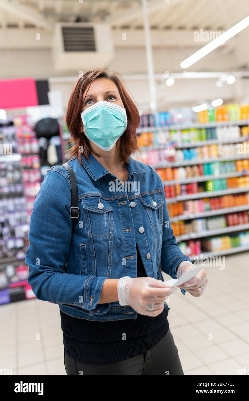 Ansicht der schönen Frau mit medizinischen Maske Shopping Stockfoto