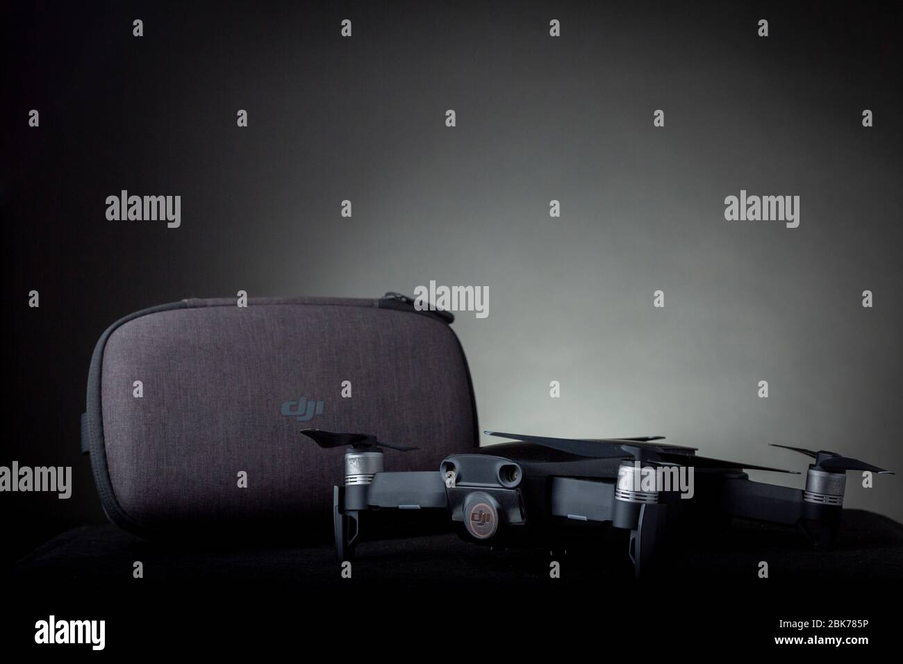 Mavic Air Quadcopter Drohne mit Schutzkappe auf Gimbal und Kamera und Hartschalentasche mit DJI Logo vor dunkelgrauem Hintergrund Stockfoto