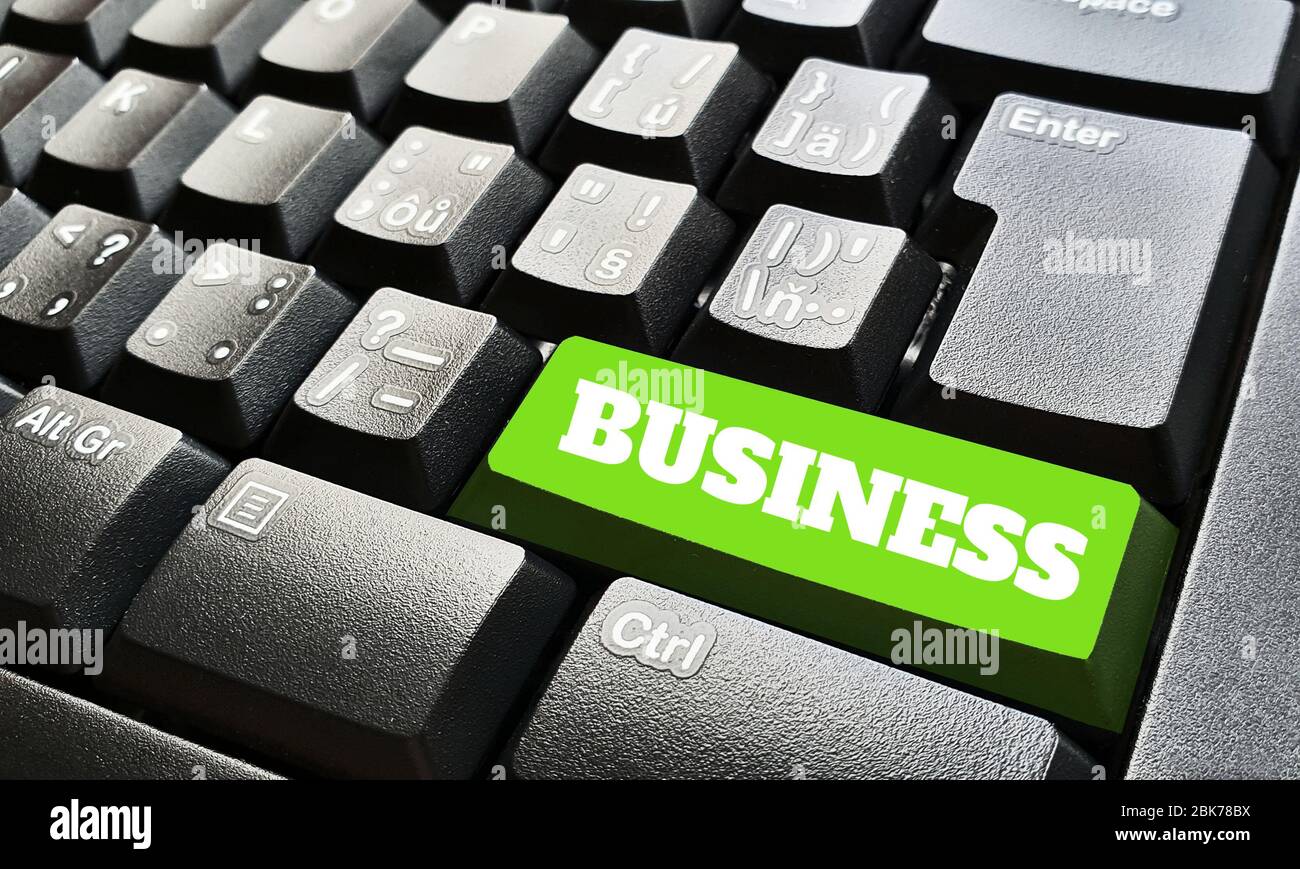 Schwarze Tastatur mit einer grünen Taste, die mit einem Geschäftszeichen gekennzeichnet ist. Stockfoto