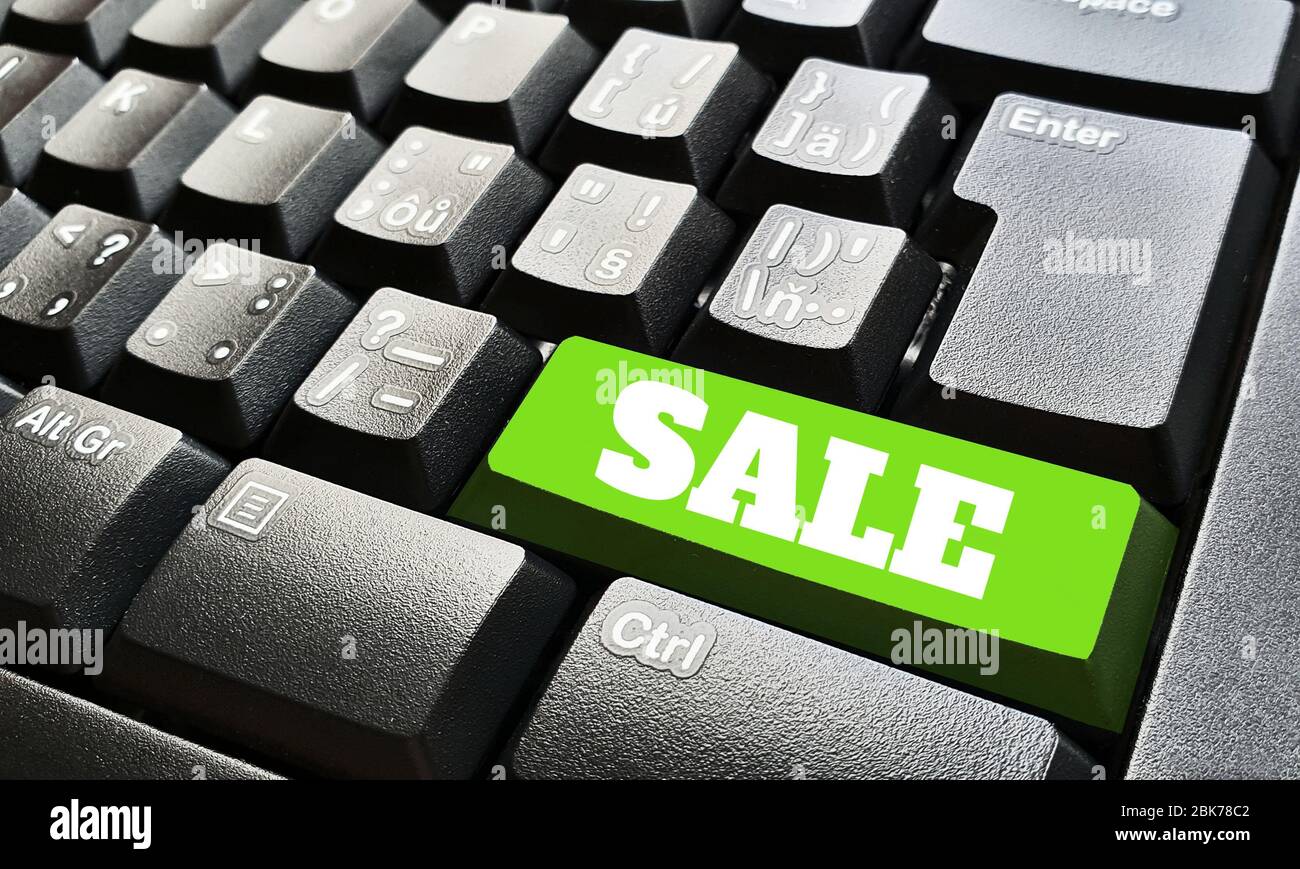 Schwarze Tastatur mit einer grünen Taste, die mit einem Verkaufsschild gekennzeichnet ist. Stockfoto