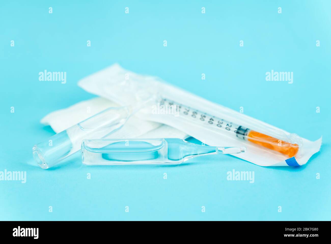 Spritze und Ampulle mit Impfstoff liegen auf blauem Hintergrund mit Platz für Text Stockfoto