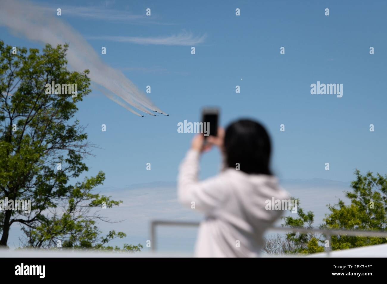 Washington, USA. Mai 2020. Eine Frau macht ein Foto von den Thunderbirds der US Air Force und den Blue Angels der Marine, die am Montag, den 2. Mai 2020, inmitten der Coronavirus-Pandemie eine Überführung zu Ehren von medizinischem Personal und Ersthelfern in Washington, DC, durchführen. Anfang dieser Woche besuchten die Überflüge der Luftwaffe und der Marine New York, da einige Bedenken geäußert haben, dass die militärischen Ressourcen besser ausgegeben werden könnten. (Graeme Sloan/Sipa USA) Credit: SIPA USA/Alamy Live News Stockfoto