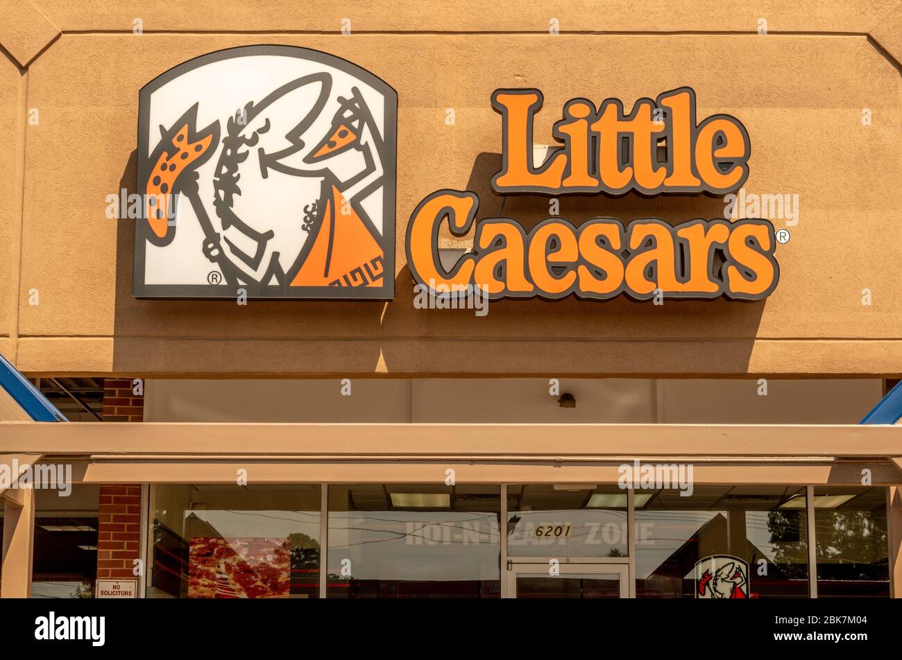Horizontale mittlere Nahaufnahme der Fassade des Pizza-Ladens „Little Caesars“ mit Marken- und Logo-Grafiken über dem Eingang des Ladens. Stockfoto