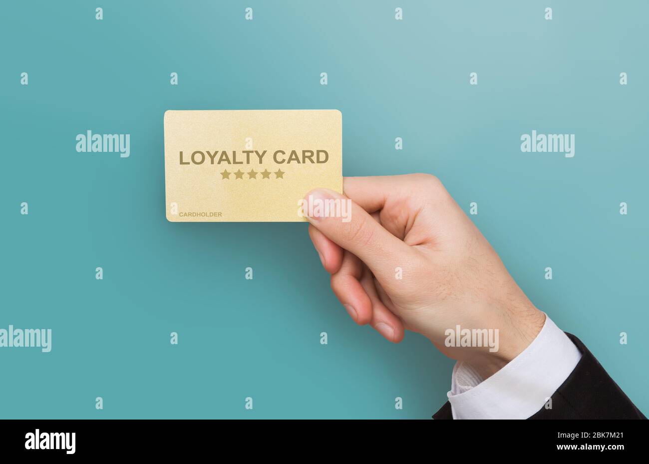 Verbraucherfreundliches Marketing. Nahaufnahme der Geschäftsmann Hand hält Loyalitäts-Karte auf blauem Hintergrund. Collage Stockfoto