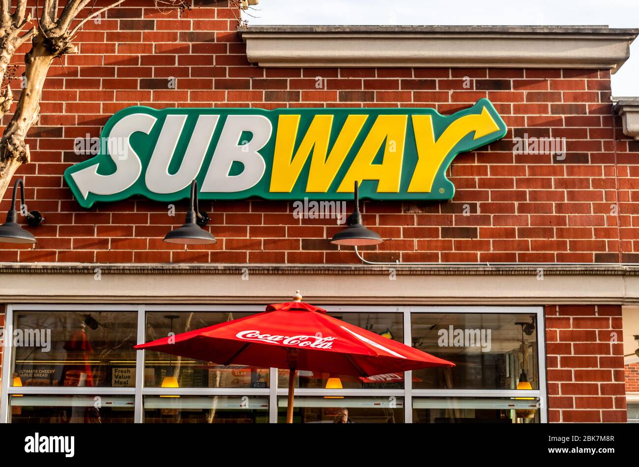Mittlere Außenansicht der Marke Subway und Logo-Beschilderung an der Fassade des Fast-Food-Stores. Stockfoto