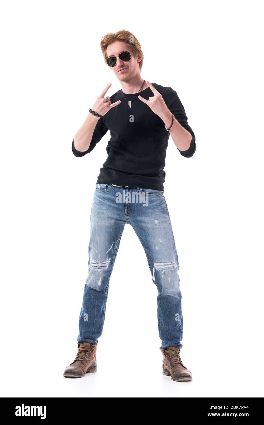 Rock and Roll Musiker in schwarzem Hemd zeigt Hard Rock Hand Zeichen Geste an der Kamera. Ganzkörper isoliert auf weißem Hintergrund. Stockfoto