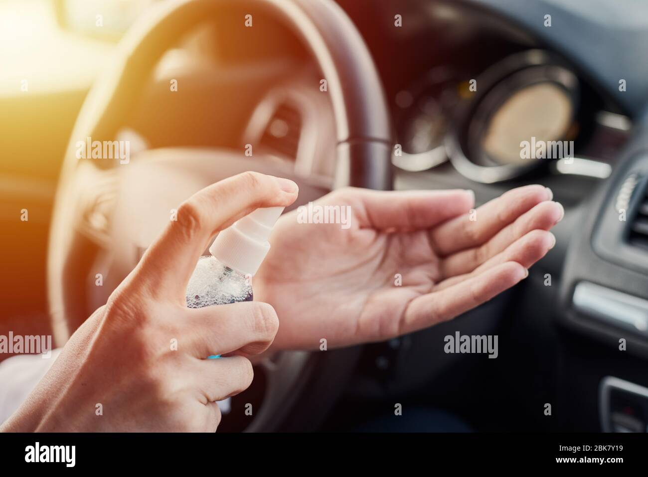 Fahrer Desinfektion Hände mit antibakteriellen Desinfektionsmittel im Auto vor der Fahrt. Vorbeugende Maßnahme zur Vorbeugung des Coronavirus Stockfoto