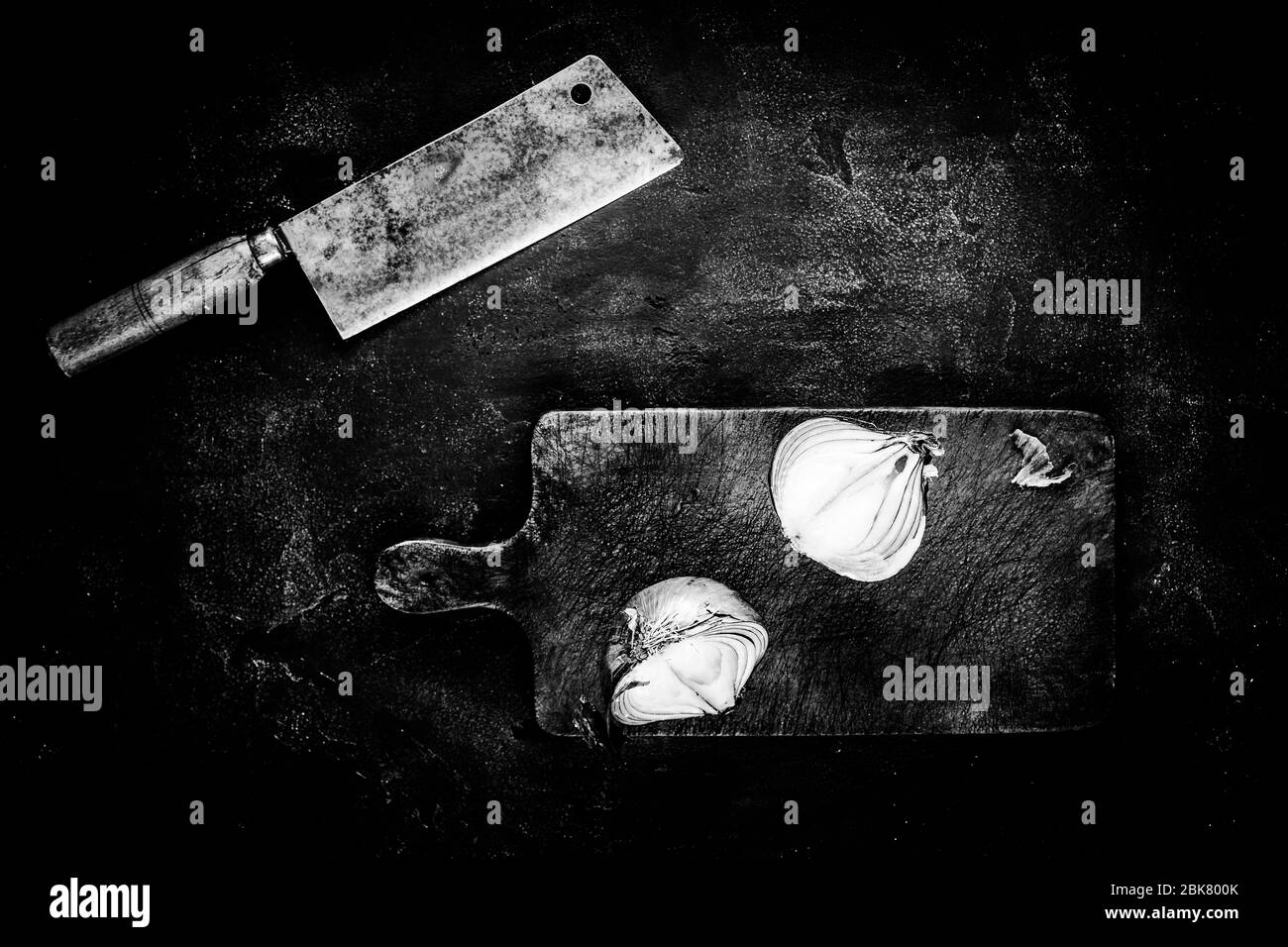 Rustikales Fleisch Cleaver und Schneidebron auf dunklem Hintergrund in Schwarz und Weiß. Konzept Der Metzgerei-Werkzeuge. Stockfoto