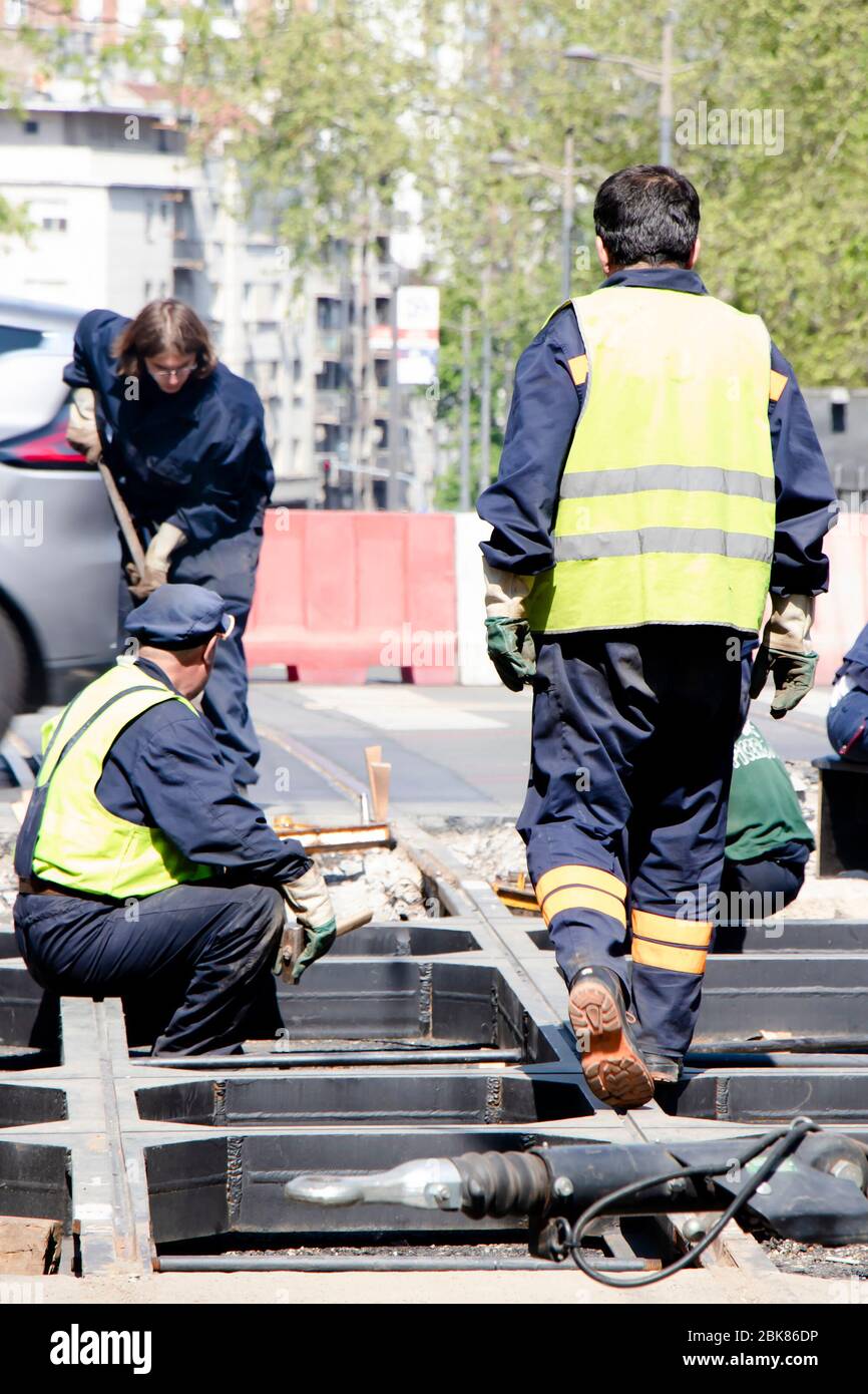 Belgrad, Serbien - 23. April 2020: Bauarbeiter arbeiten an der Straßenkreuzung der Stadt und ersetzen alte verrottete Straßenbahnschienen durch neue Stockfoto