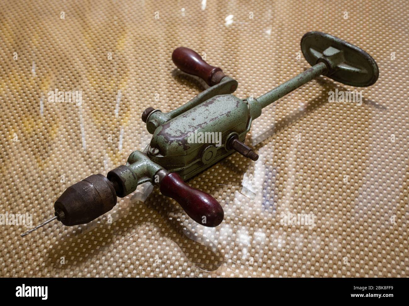 Sehr alte, gebrauchte, antike Handbohrmaschine für Holzbearbeitung auf dem Glastisch, Vintage-Objekt, isoliert Stockfoto