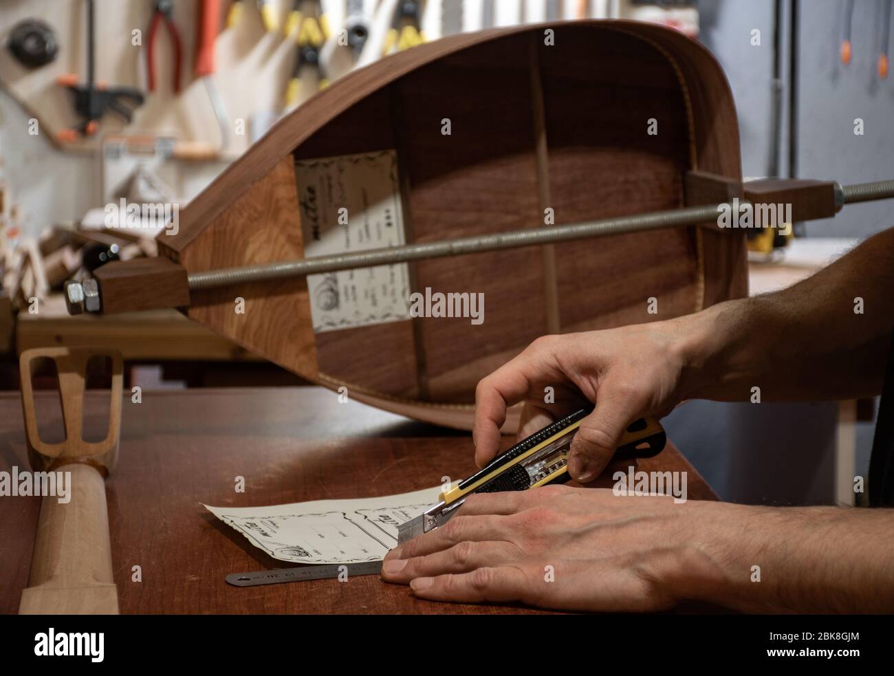 Eine Nahaufnahme Szene von Geigenhändigen Schneiden handgefertigten Titel für hölzerne Musikinstrumente Stockfoto