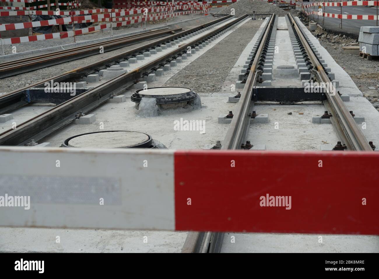 Baustelle einer Straße-Auto-Linie, Einbettung von Metallschienen in einem Betonsockel mit einer Barriere Planken für die Sicherheit. Stockfoto