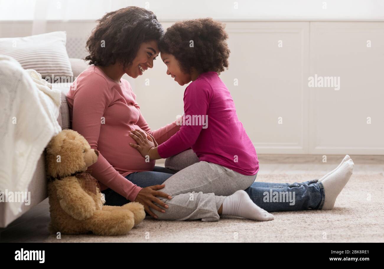 Glücklich Schwanger Schwarz Frau Und Sie Süß Tochter Bonding Bei Zu Hause Stockfoto
