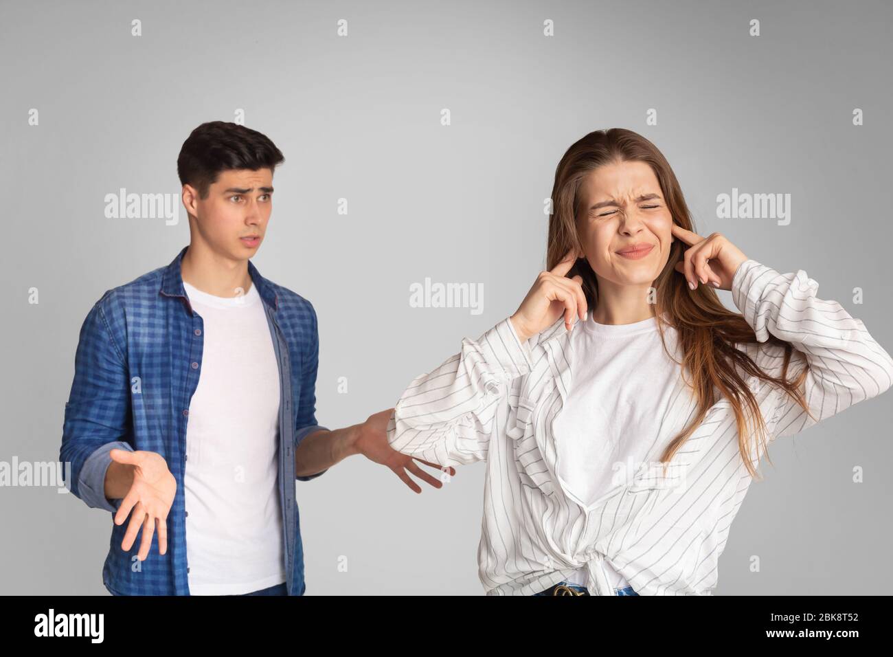 Junges Paar streitsüchtig, Mädchen deckt Ohren mit Händen Stockfoto