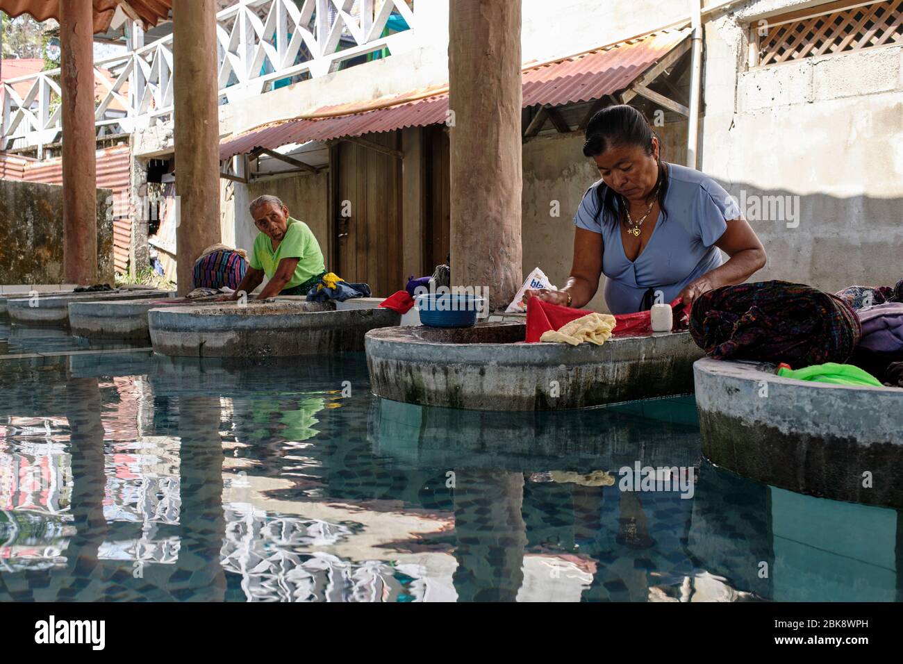 Frauen waschen Kleidung von Hand in einer öffentlichen Wäscherei. Stockfoto