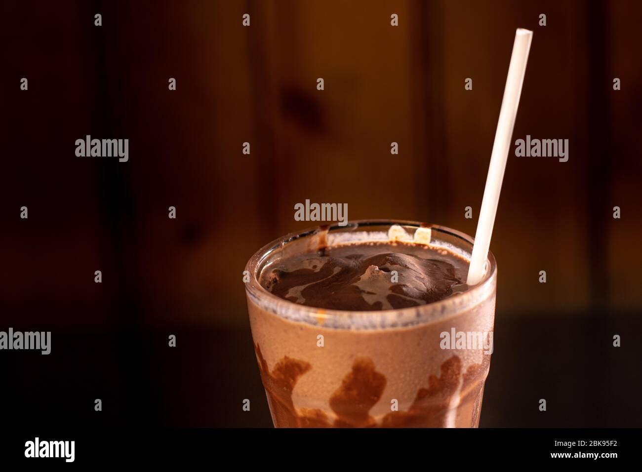 Leckerer Milchshake im Glas auf Holz Stockfoto