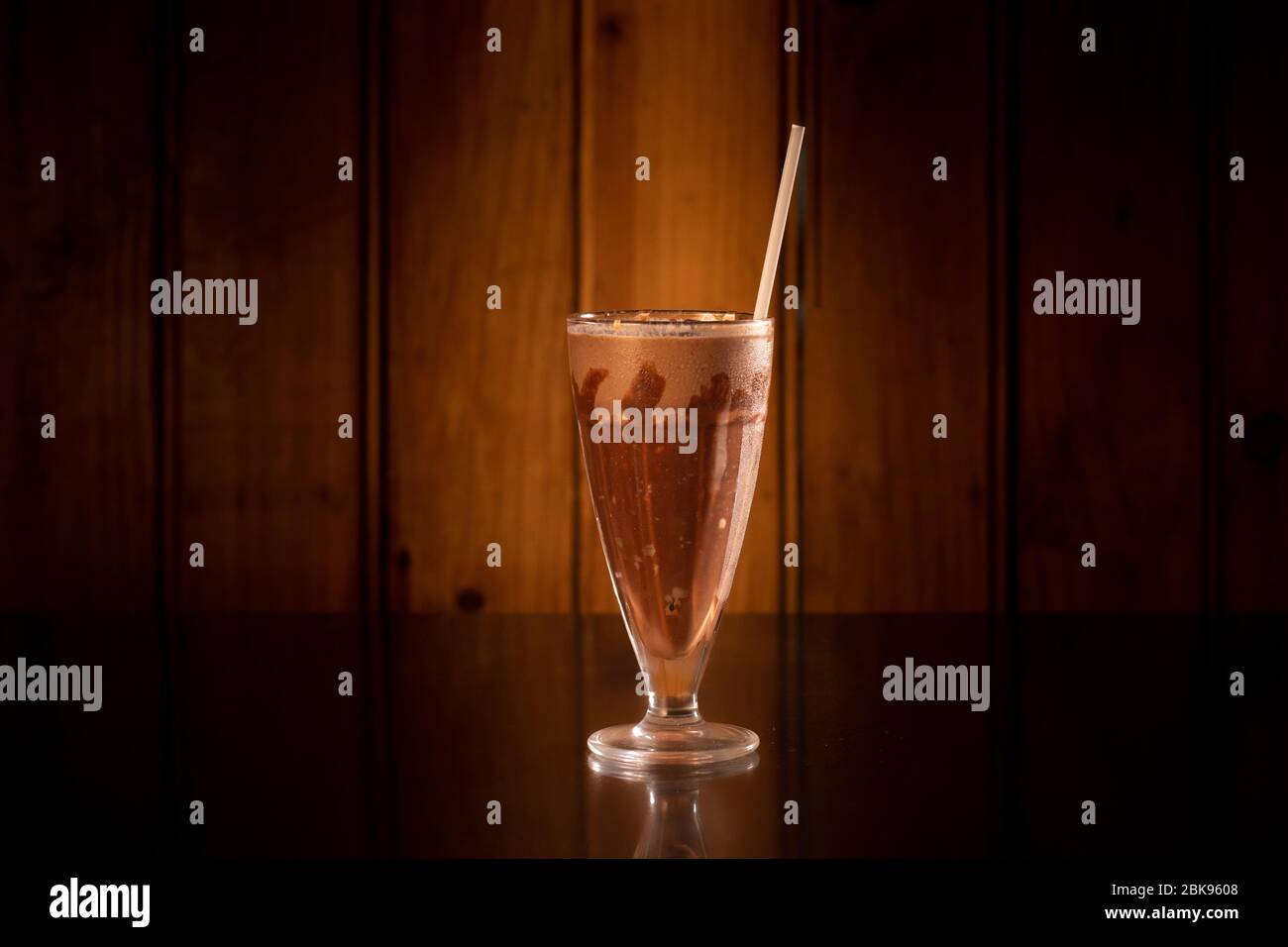 Leckere Milchshake im Glas auf Holzhintergrund Stockfoto