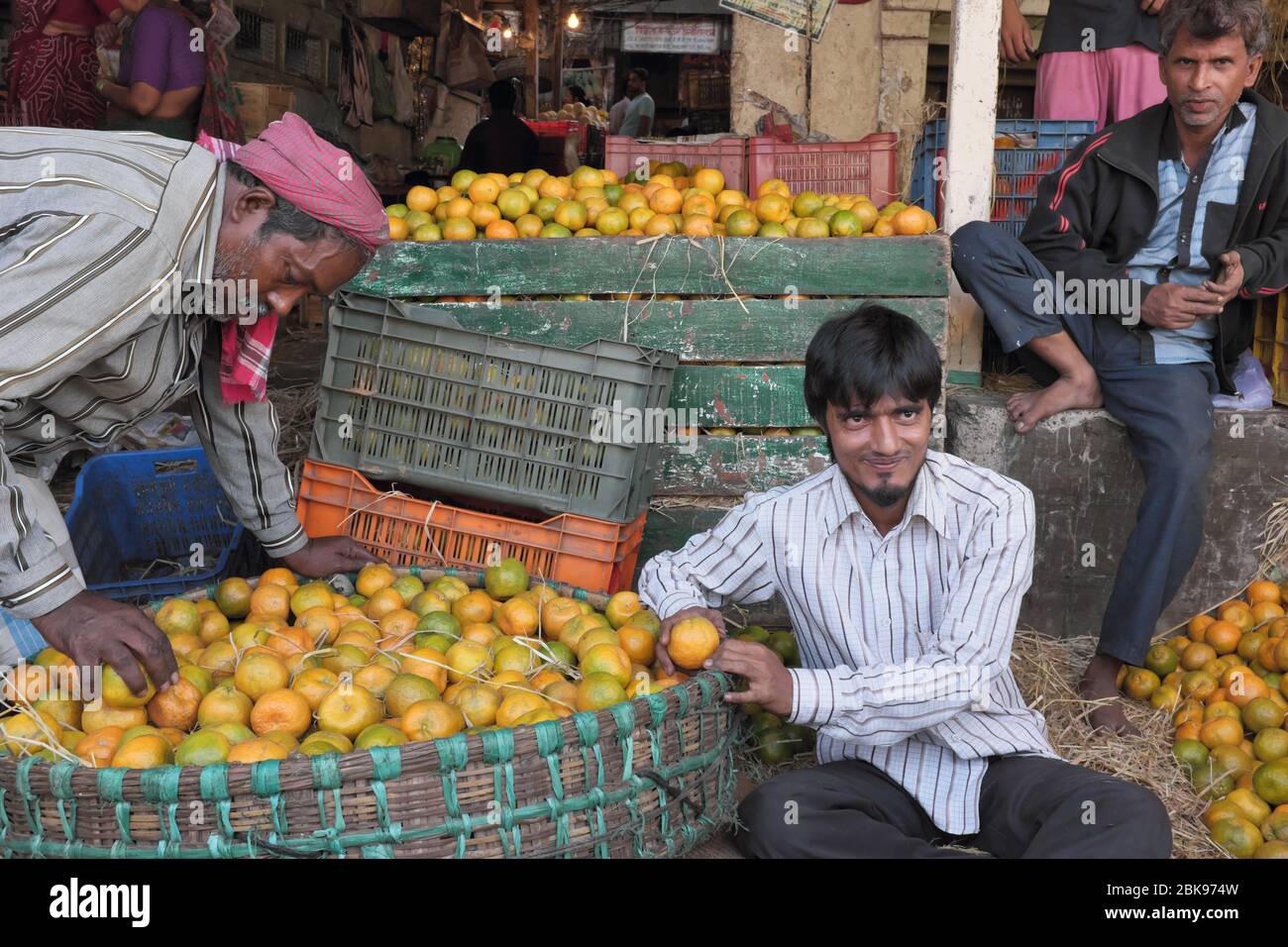 Obsthändler, Migranten aus Nordindien, mit großen Körben Orangen auf dem Byculla Market, Byculla, Mumbai, Maharashtra, Indien Stockfoto