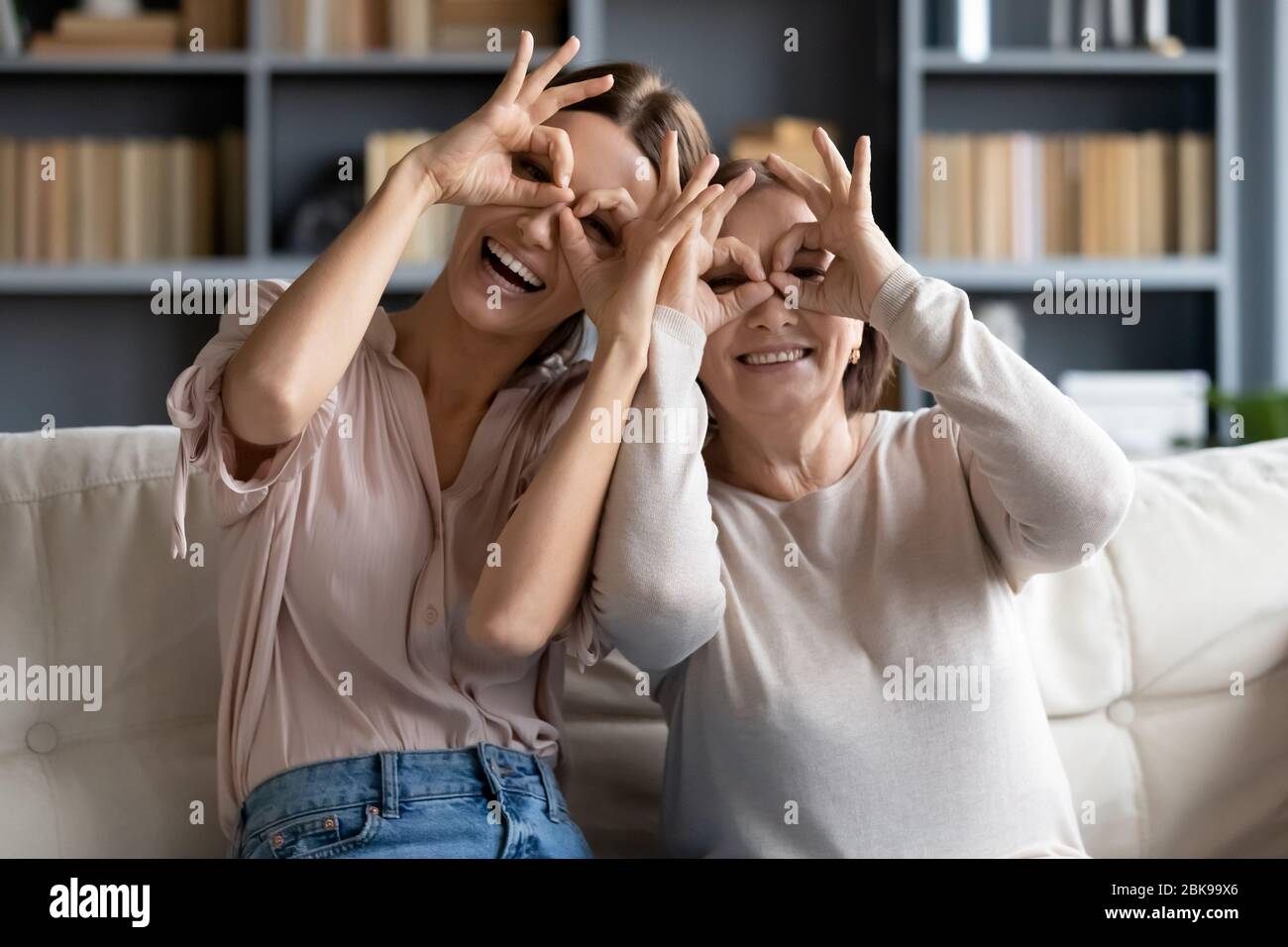 Lustige Porträt Erwachsene Tochter und reife Mutter machen Fernglas Geste Stockfoto