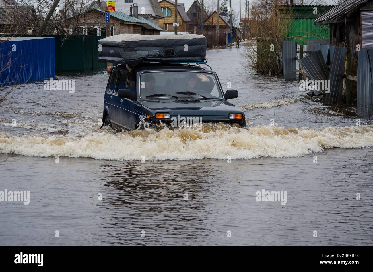 Mai 2020 - Archangelsk. Russische Offroad-Auto Niva fährt auf einer überfluteten Straße. Russland, Region Archangelsk Stockfoto