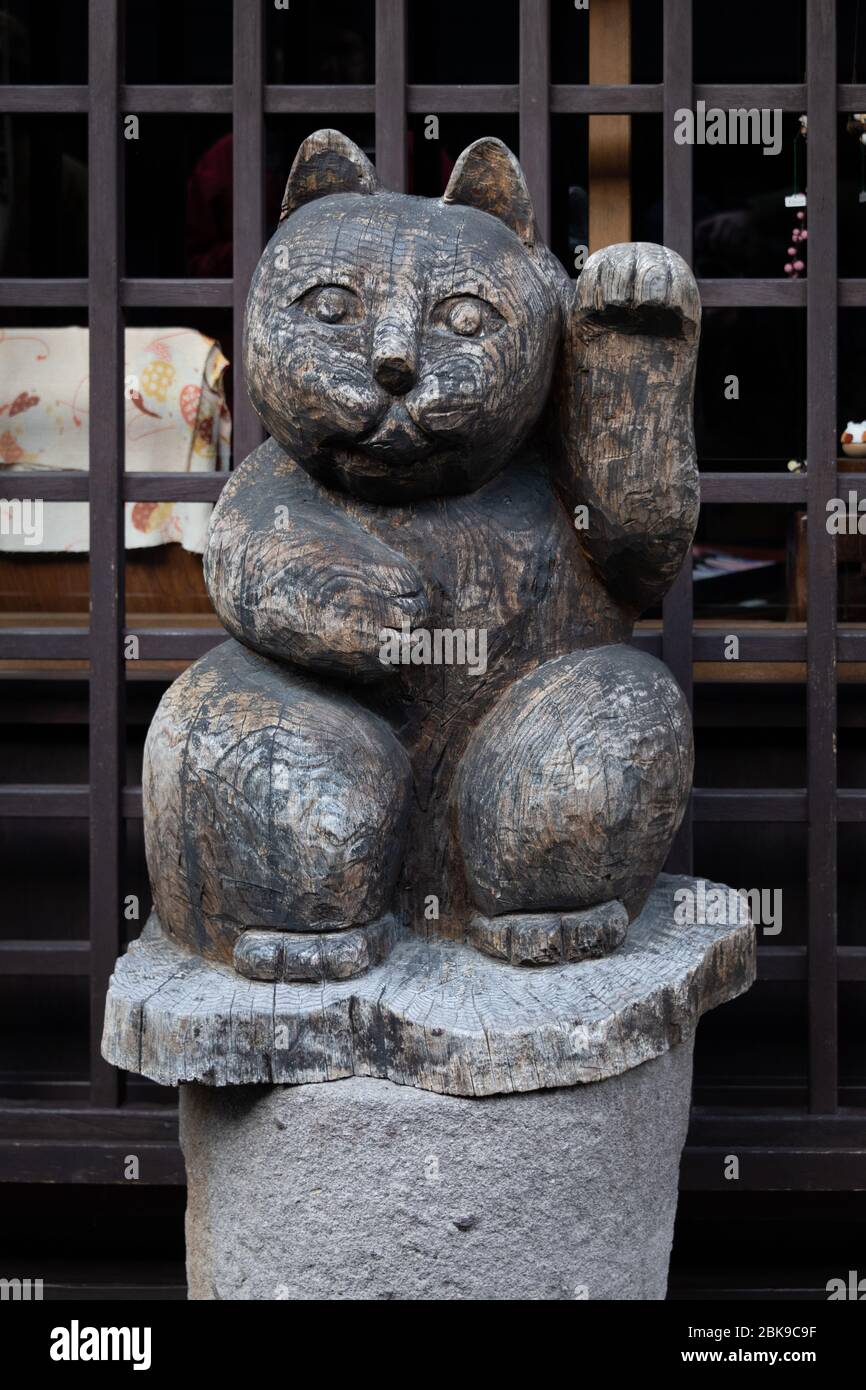 Geschnitzte hölzerne Glückspilz (maneki neko) Stockfoto