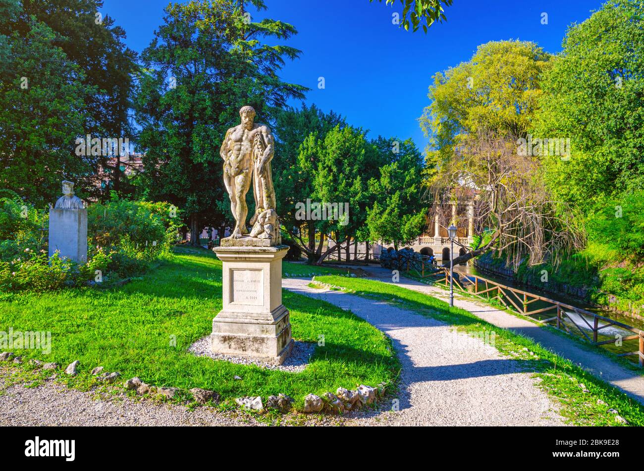 Vicenza, Italien, 12. September 2019: Farnese Hercules Ercole Farnese die alte Statue des Herkules in Salvi Gärten Park mit grünen Bäumen, Valmarana Lodge Gebäude, historisches Stadtzentrum, Venetien Region Stockfoto