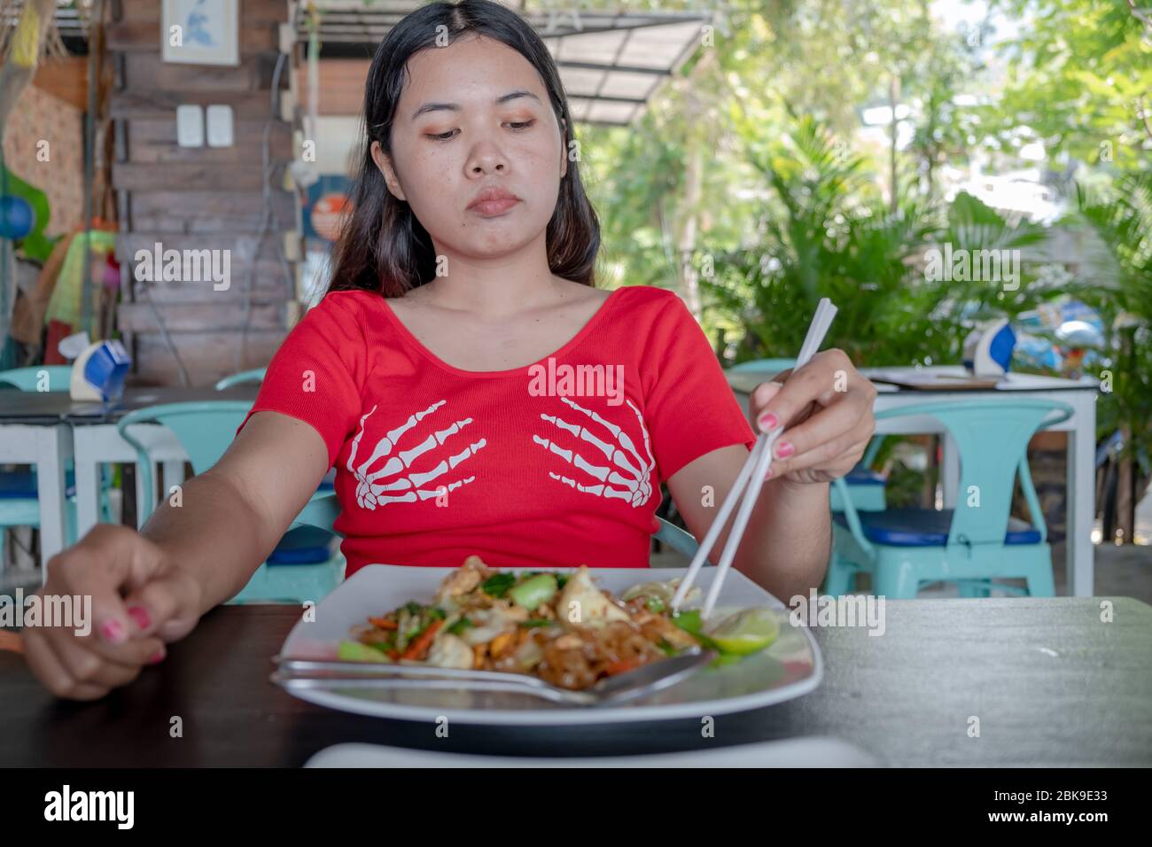 Thai Dame mit Bambus Essstäbchen zum Essen Pad thai Essen im Restaurant Stockfoto