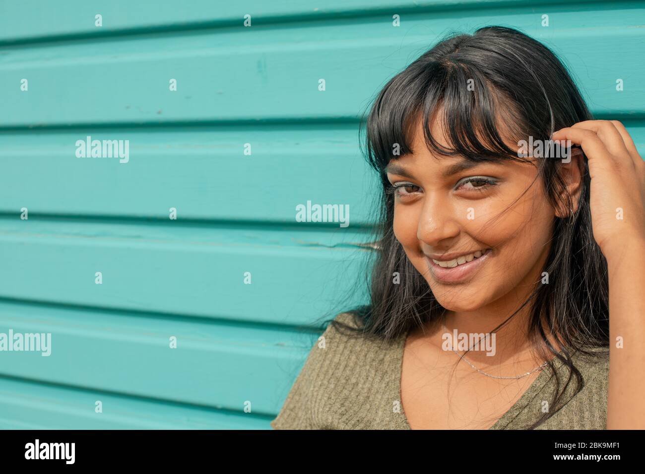 Junge Frau steht gegen Garagentor Stockfoto