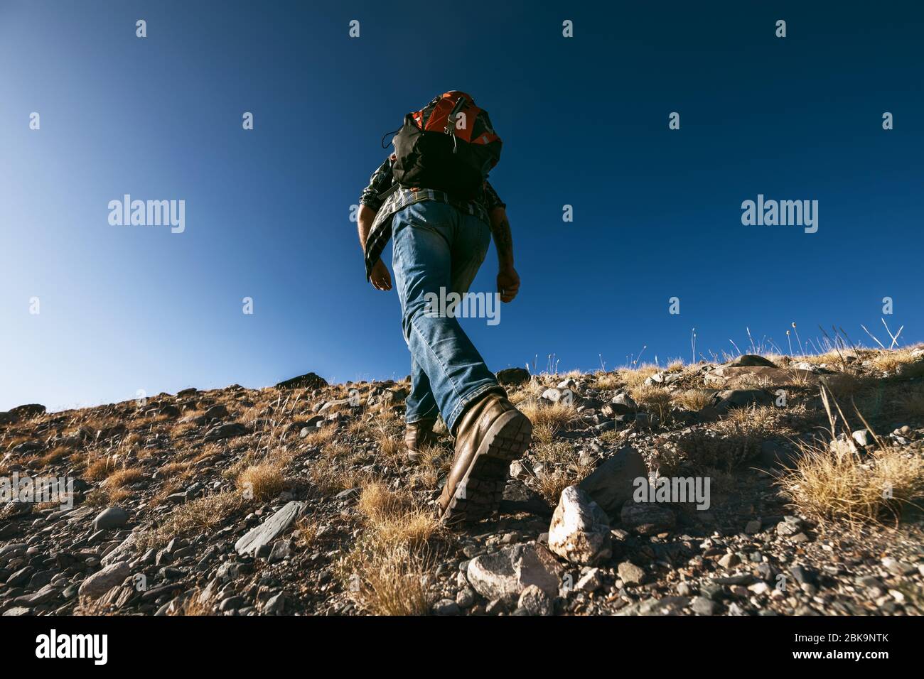 Unkenntlich männlicher Reisender oder Wanderer geht bergauf. Nahaufnahme Foto von Stiefeln Stockfoto