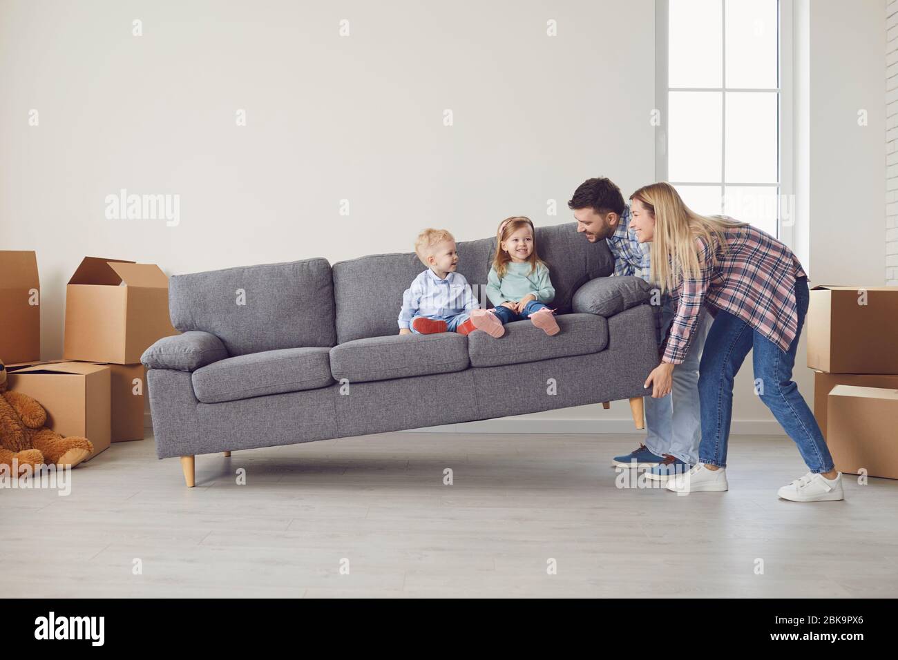 Glückliche Familie mit Kindern Umzug spielen in einem neuen Mehrfamilienhaus. Stockfoto