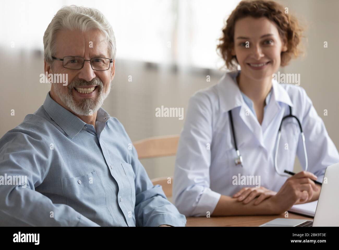 Glücklich gesund männlichen Senior Patient suchen Kamera Besuch Arzt Stockfoto