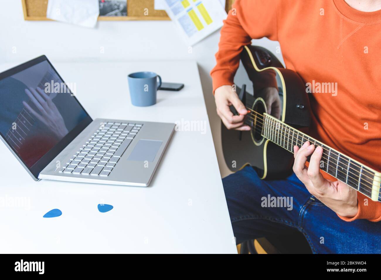 kaukasischer Mann lernen, akustische Gitarre mit Video-Unterricht zu spielen Stockfoto