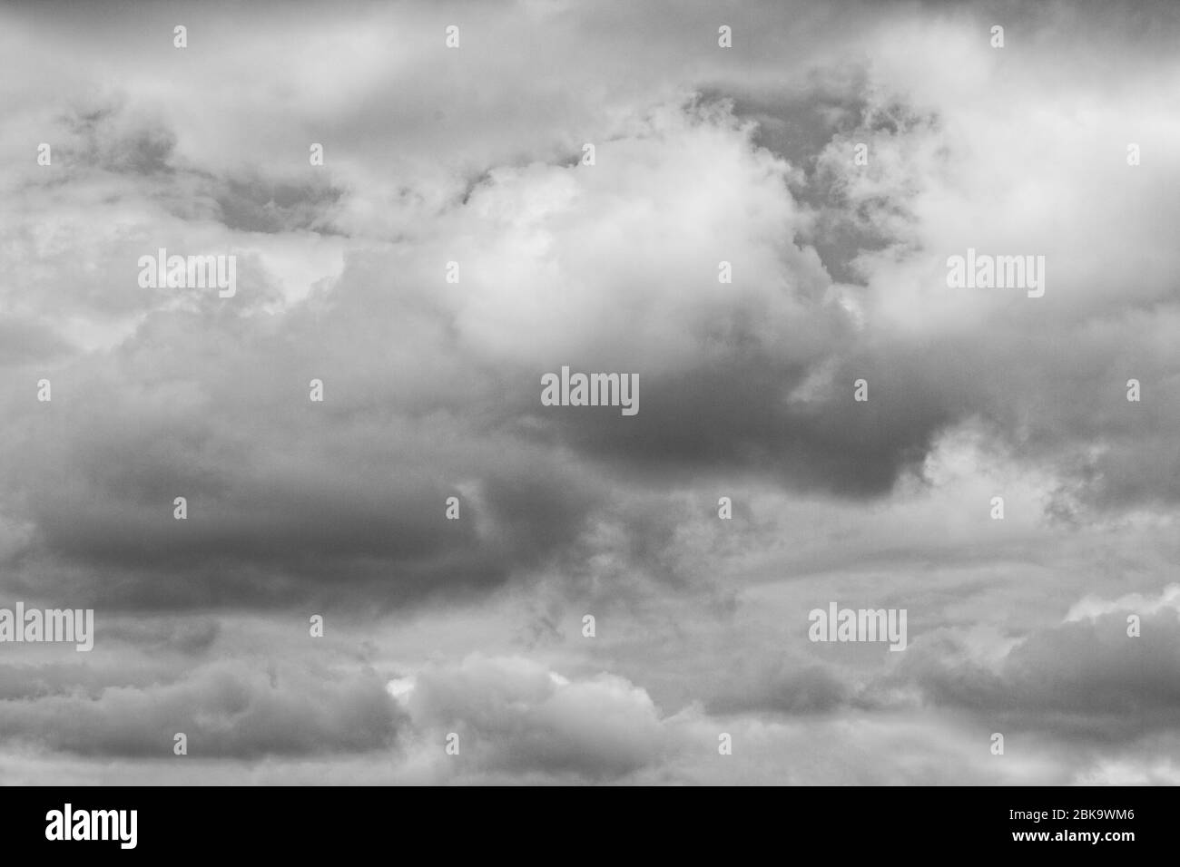Dunkle, schwere Regenwolken versammeln sich vor einem blauen Himmel. Stockfoto