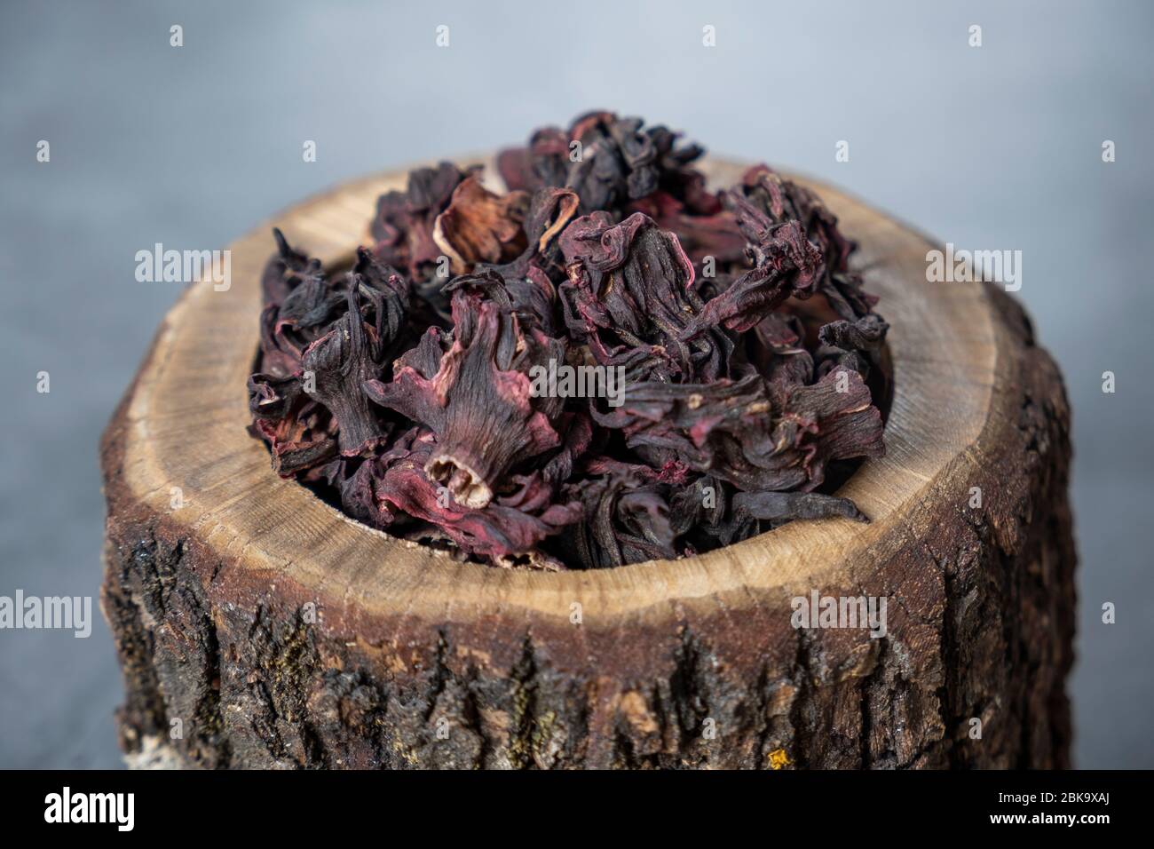 Hibiskus-Tee in Holzschale. Trockene, biologische, gesunde und entspannende Kräuter. Stockfoto