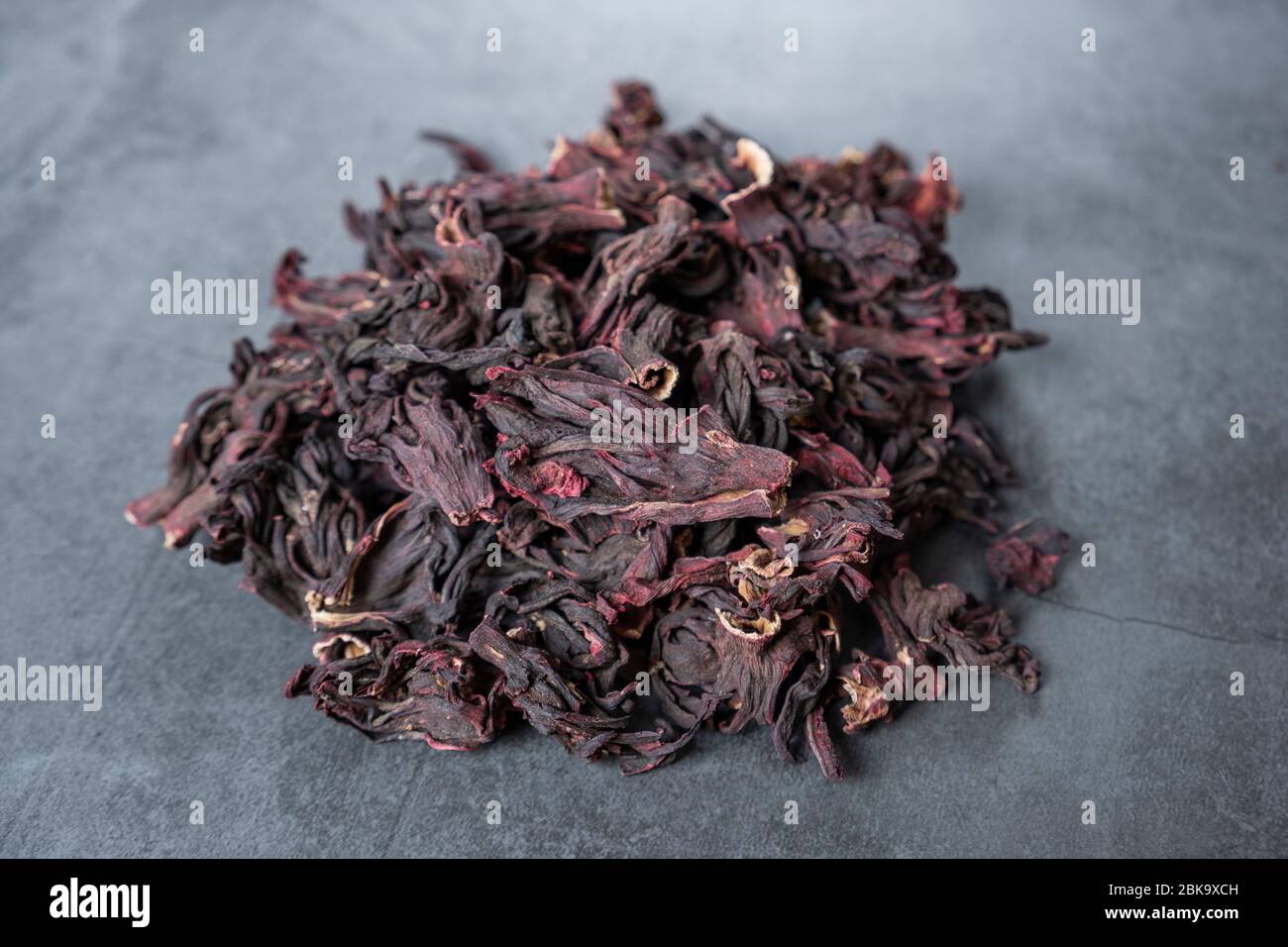 Hibiskus Tee auf Stein, Beton Hintergrund. Trockene, biologische, gesunde und entspannende Kräuter. Stockfoto