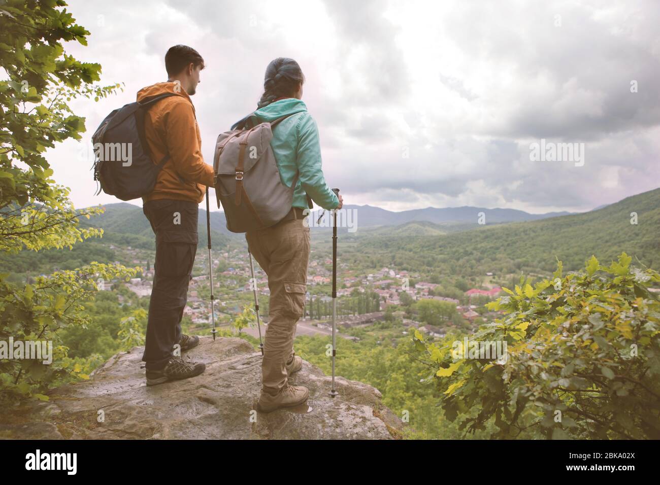 Junges Paar, das am Rand steht und auf die Berge starrt. Tonbild. Stockfoto