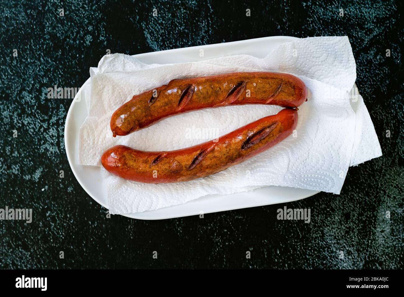 Hausgemachte Bratwurst mit Papiertuch auf Teller. Bereit zum Servieren und Essen. Fast Food. Stockfoto