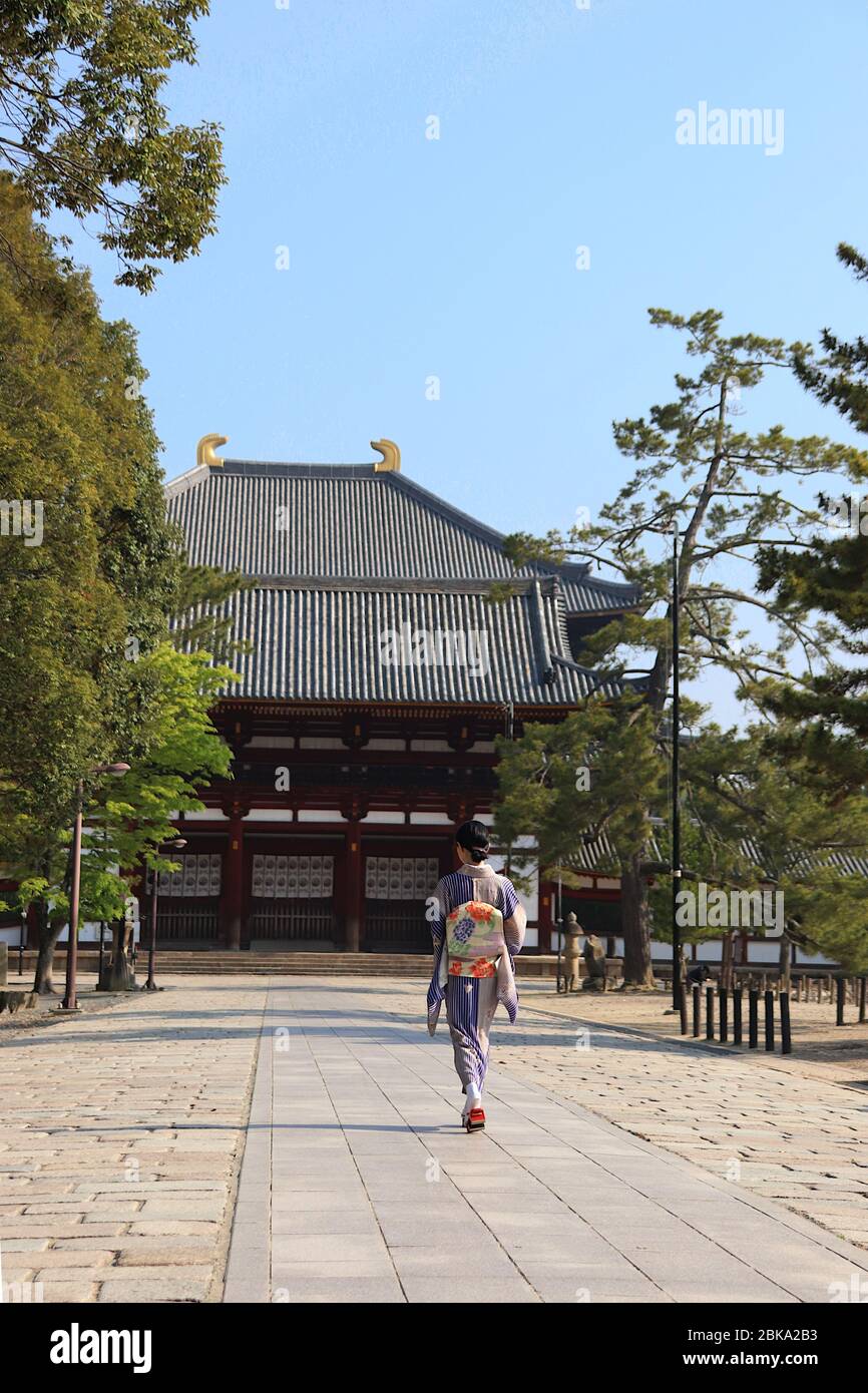 Japanische Frau im Kimono, die zu einem buddhistischen Tempel geht Stockfoto