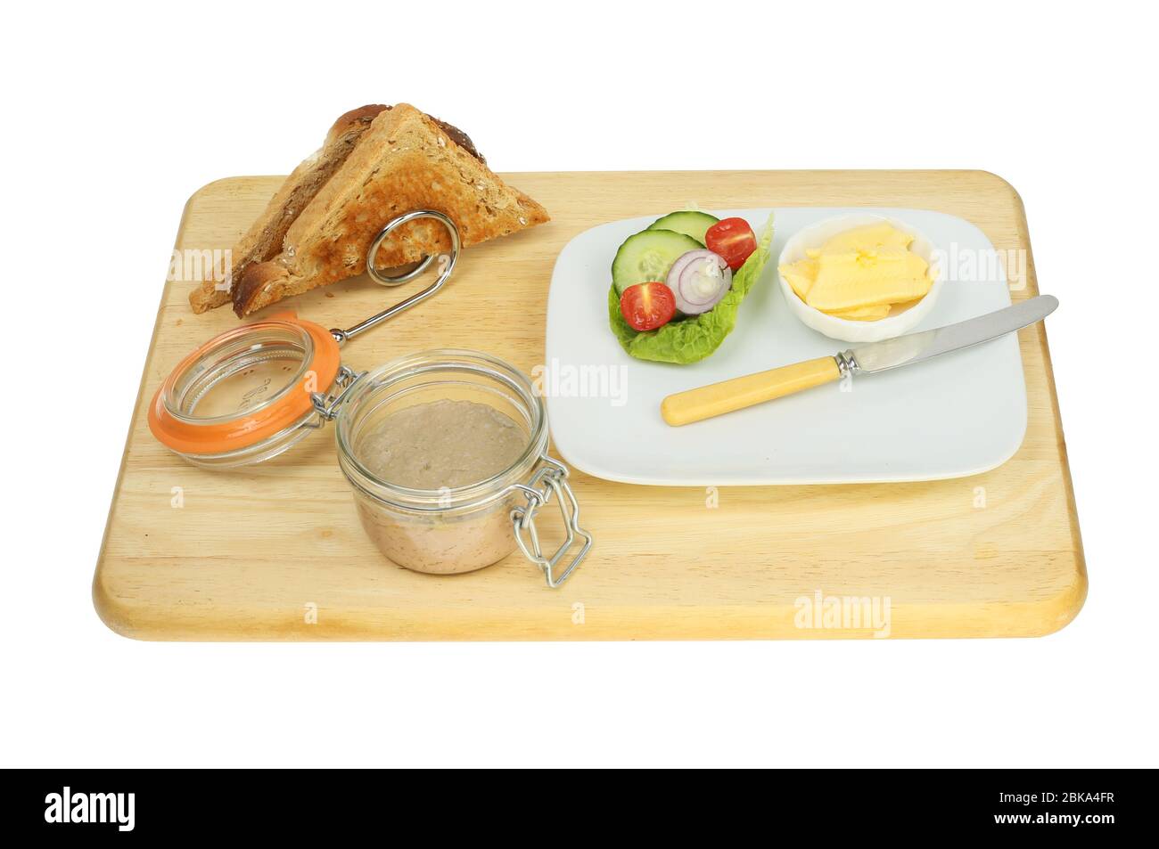 Paste in ein Glas mit Toast in einem Rack und Salat auf einem Teller mit einem Messer auf einem Holzbrett isoliert gegen weiß Stockfoto