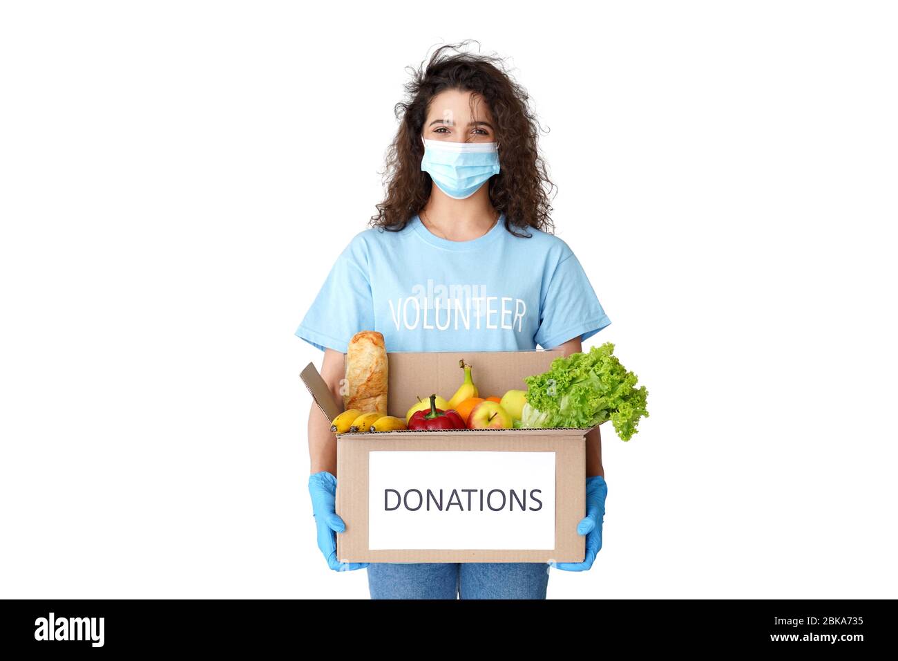 Hispanic Mädchen Kurier Freiwillige tragen Maske halten Spende Box mit Lebensmitteln Lieferung. Stockfoto