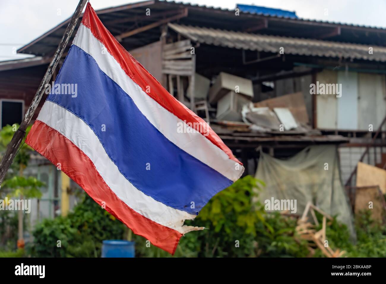 Die Nationalflagge Thailands flattert auf der Straße am Stadtrand. Stockfoto