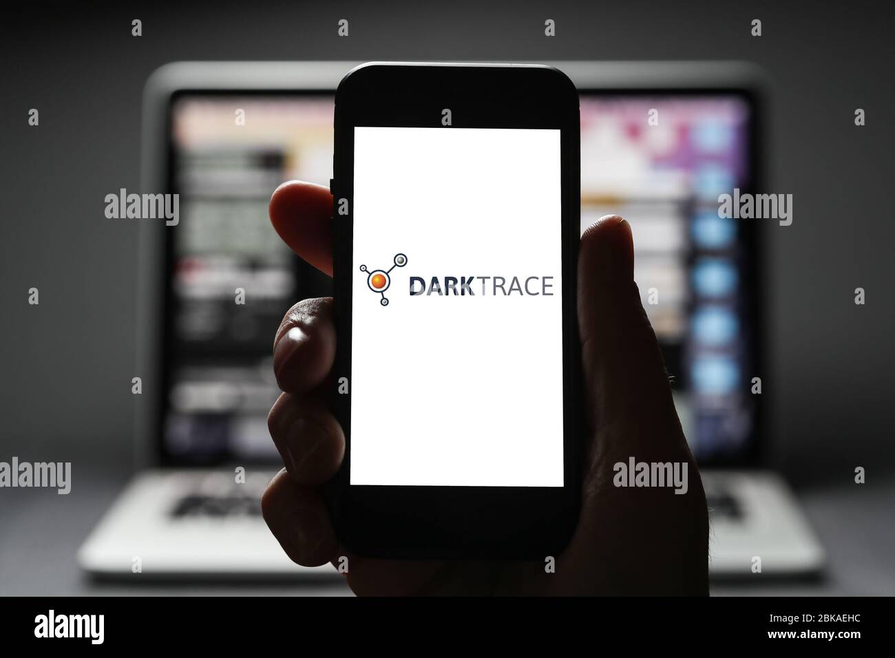 Ein Mann, der das Logo für Darktrace auf seinem iphone ansieht. Darktrace ist ein Entwickler-Unternehmen für Cybersicherheit, das 2013 von Mathematikern der Universität gegründet wurde Stockfoto