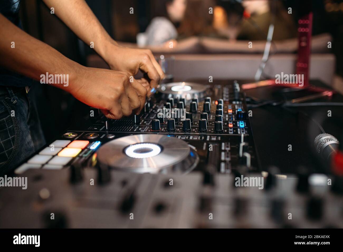 Nahaufnahme von DJ's Hand spielen Musik am Plattenteller auf einem Party-Festival - Porträt von DJ Mixer Audio in einem Beach Club über der Menge tanzen und mit f Stockfoto