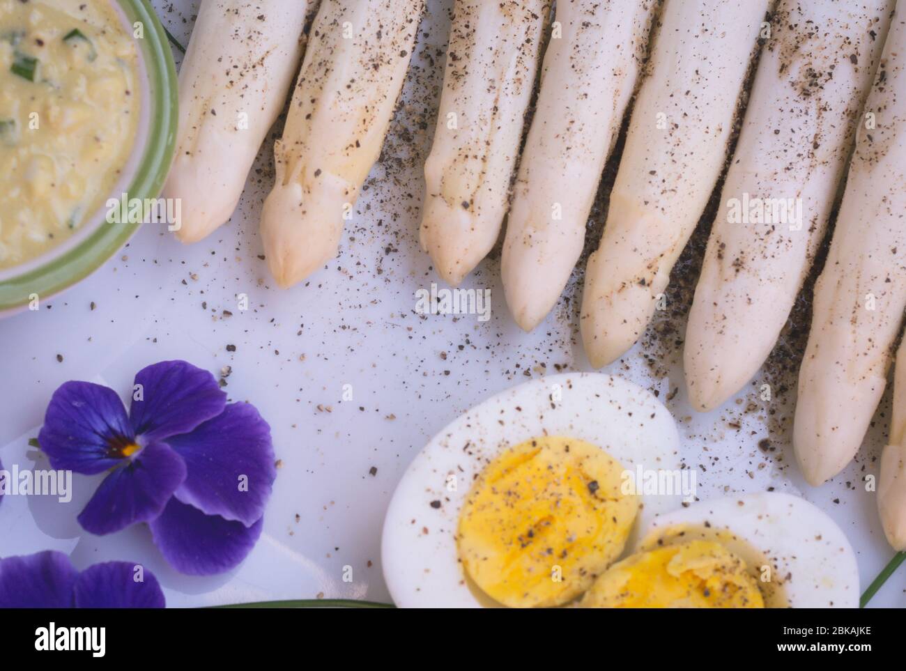 Bund frischer, ungekochter weißer Spargel und gekochte Eier, neue Ernte, aus nächster Nähe. Filtereffekt. Gemüse der Saison. Selektiver Fokus Stockfoto