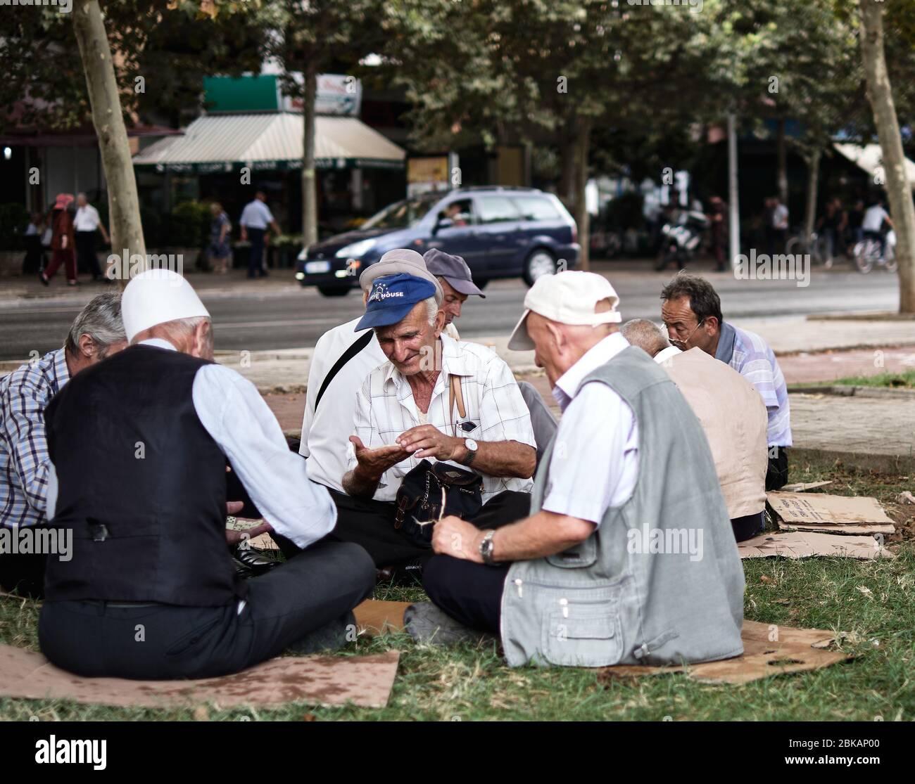 Alte Männer spielen das Spiel Domino im Schatten der Bäume. Stockfoto