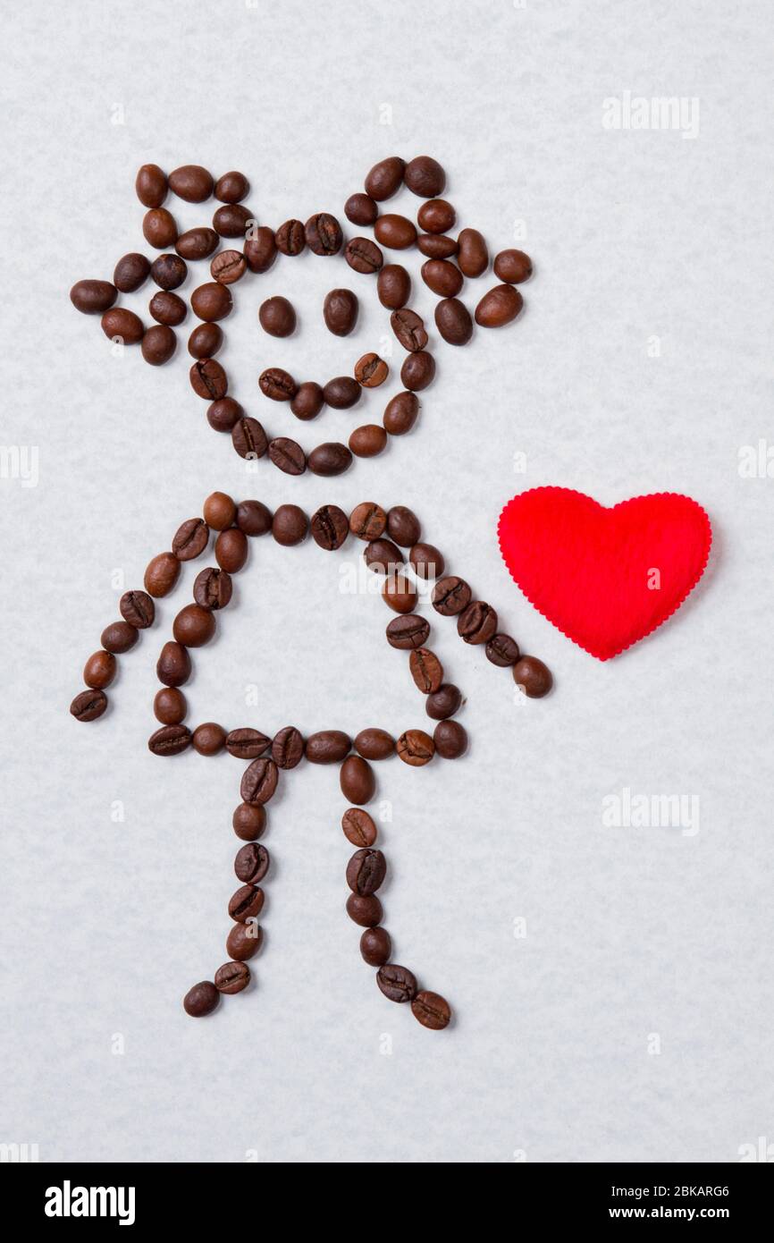 Mädchen aus Kaffeebohnen und rotem Herz. Stockfoto