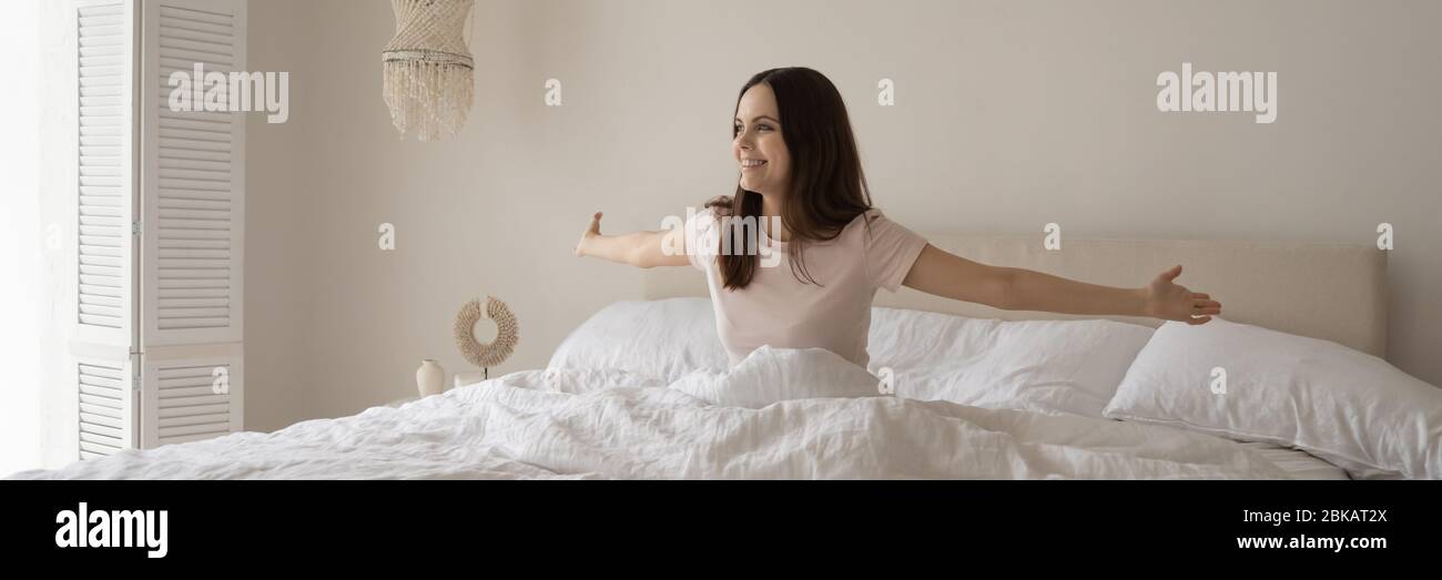 Glückliche junge Frau erwachen in komfortablen großen Bett Stockfoto