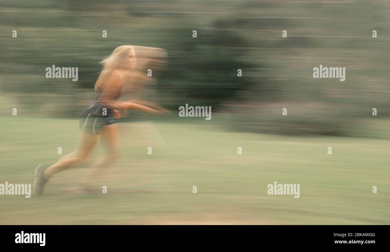Ein Mädchen läuft in unscharfen Bewegungen Stockfoto